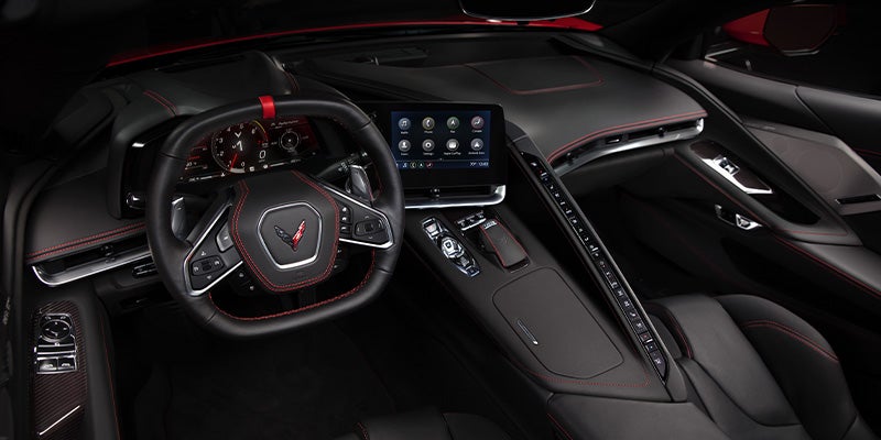 A close-up of the Corvette's driver-focused cockpit with a digital display and steering wheel