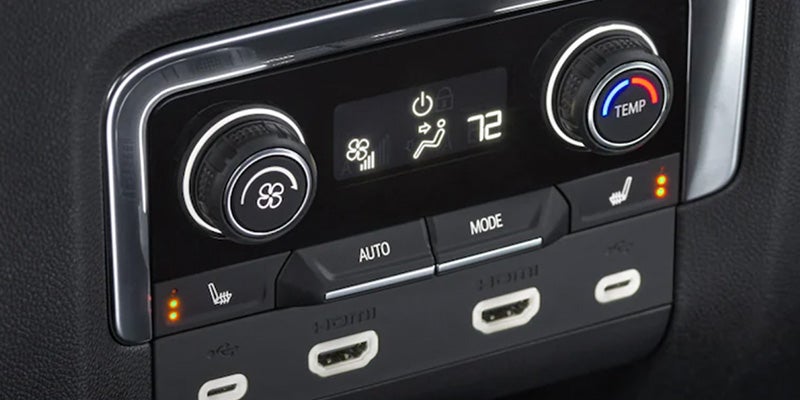 A close-up of the vehicle's climate control system with digital displays and buttons.