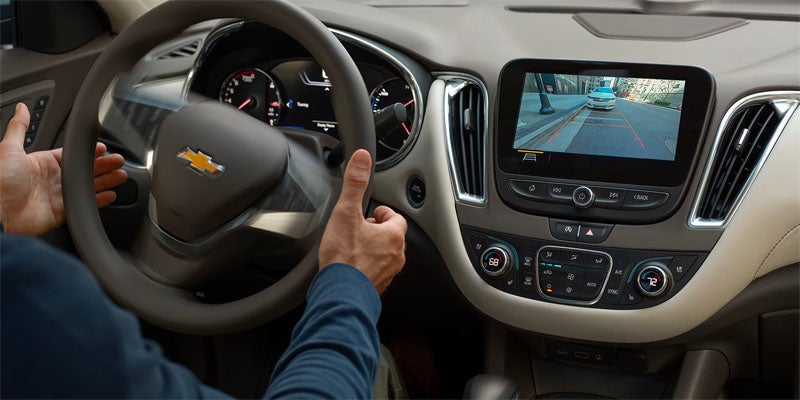 Man inspecting the front dashboard of 2025 Chevrolet Malibu