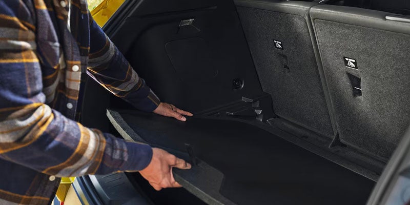 Man closing the rear storage space of the 2025 Chevrolet Trailblazer