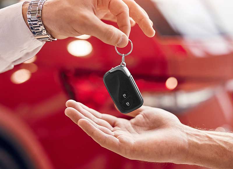 car owner giving key to sales person